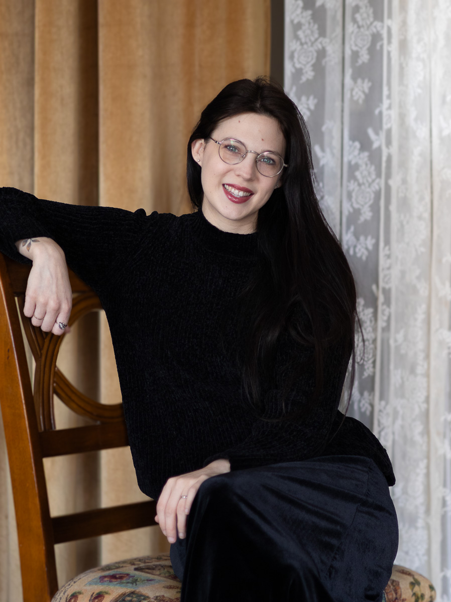 Photographer Alayna Darlene sitting in a chair, natural light portrait